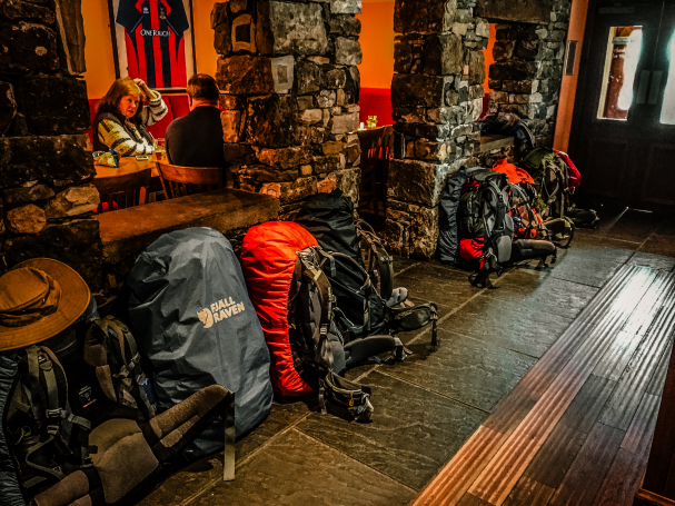 Hiking backpacks lined up inside a traditional Highland pub on the Isle of Skye, Scotland.