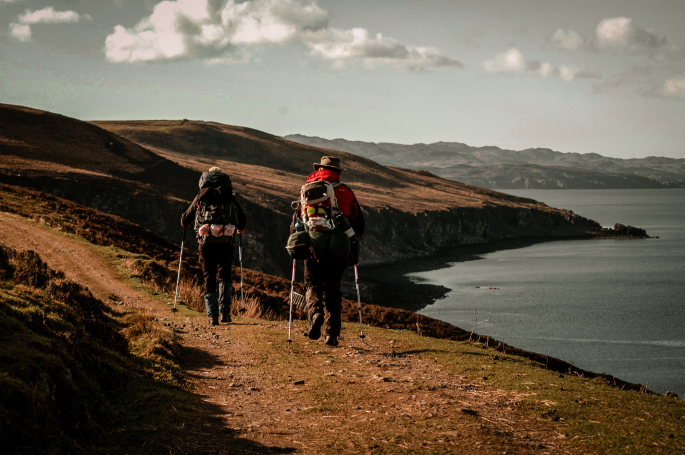 Hiker walking along a trail on the Isle of Skye, Scotland.