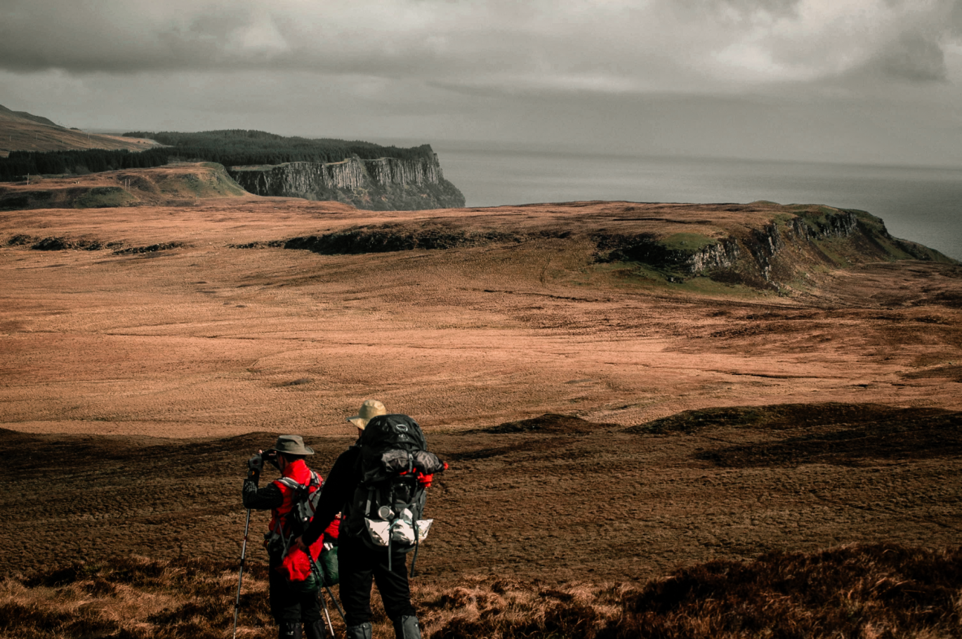 Hikers walking along the coastal trail on the Isle of Skye, Scotland.